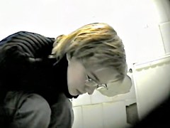 Blonde in glasses getting in the public toilet