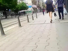 Brunette dish has her black skirt lifted up by the wind
