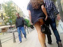 Brunette dish has her black skirt lifted up by the wind