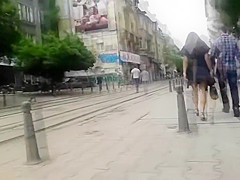 Brunette dish has her black skirt lifted up by the wind