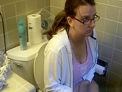 Busty woman in bathroom toilet peeing