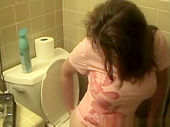 Busty woman in bathroom toilet peeing