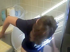 Busty woman in bathroom toilet peeing