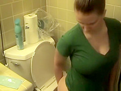 Busty woman in bathroom toilet peeing