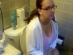 Busty woman in bathroom toilet peeing
