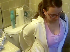 Busty woman in bathroom toilet peeing