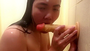 Horny Asian girl fucking a dildo while showering at the gym