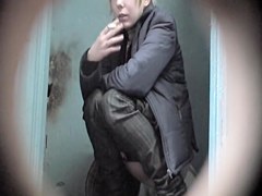 Pretty blonde is smoking and pissing on the toilet